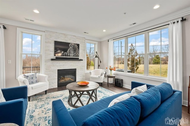 living room with wood finished floors, a fireplace, visible vents, and recessed lighting