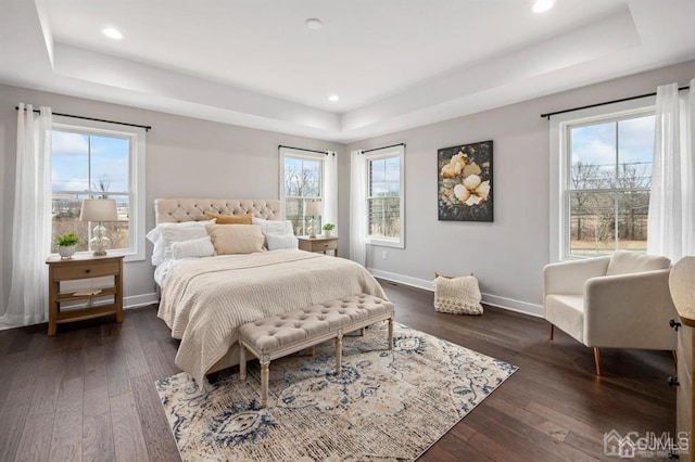 bedroom with a tray ceiling, baseboards, and multiple windows