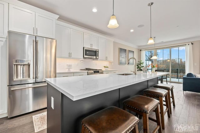 kitchen featuring tasteful backsplash, ornamental molding, stainless steel appliances, and a sink