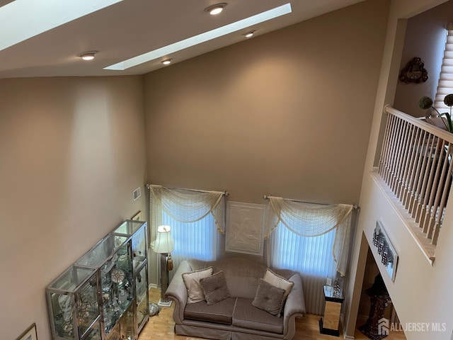 living room with a towering ceiling and a skylight