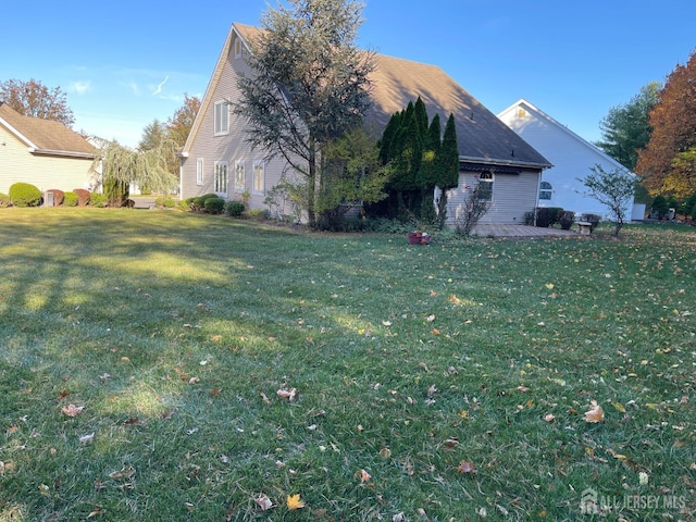 view of property exterior featuring a patio and a lawn