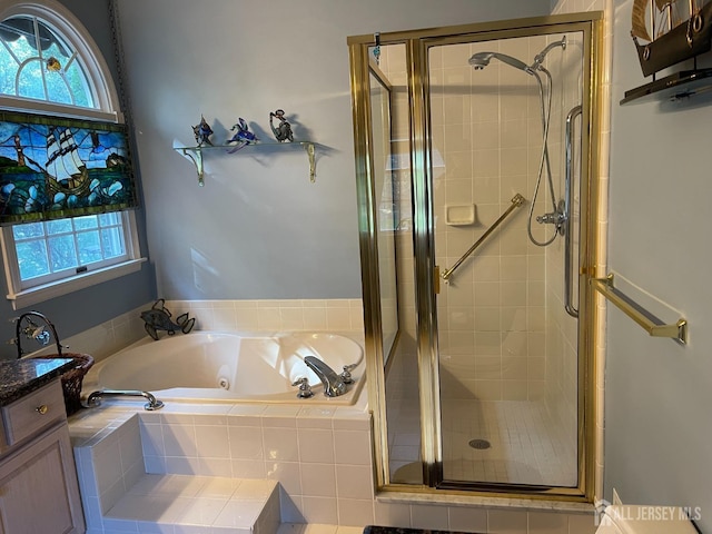 bathroom with shower with separate bathtub, a healthy amount of sunlight, and vanity