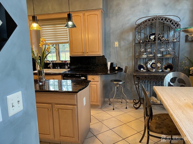 kitchen with sink, light tile patterned floors, light brown cabinets, dishwasher, and pendant lighting