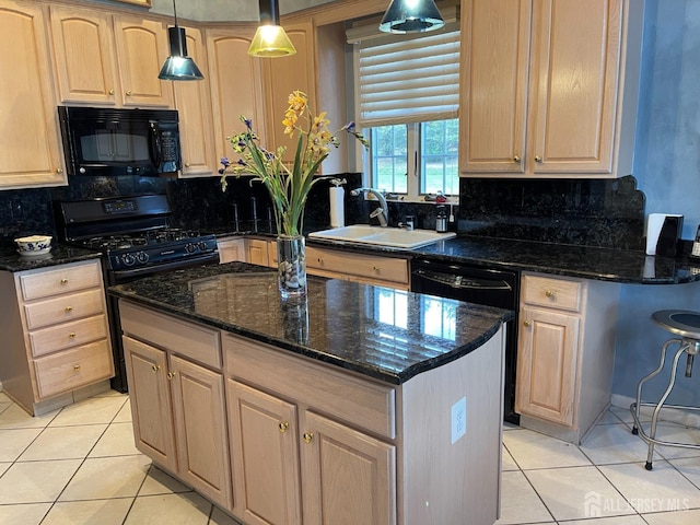 kitchen with decorative light fixtures, sink, dark stone counters, and black appliances