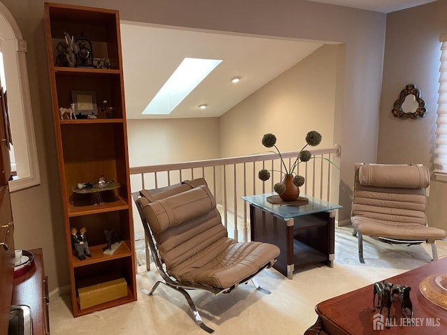 living area with light carpet and a skylight