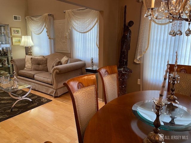 dining room with light hardwood / wood-style flooring and a chandelier