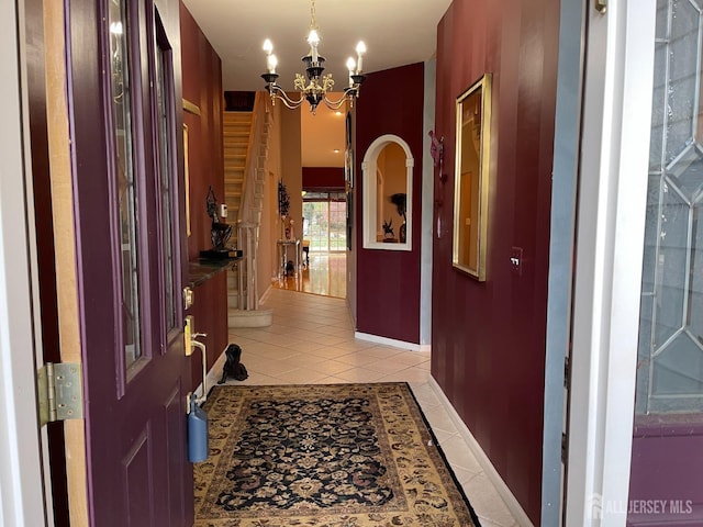 corridor with light tile patterned flooring and an inviting chandelier