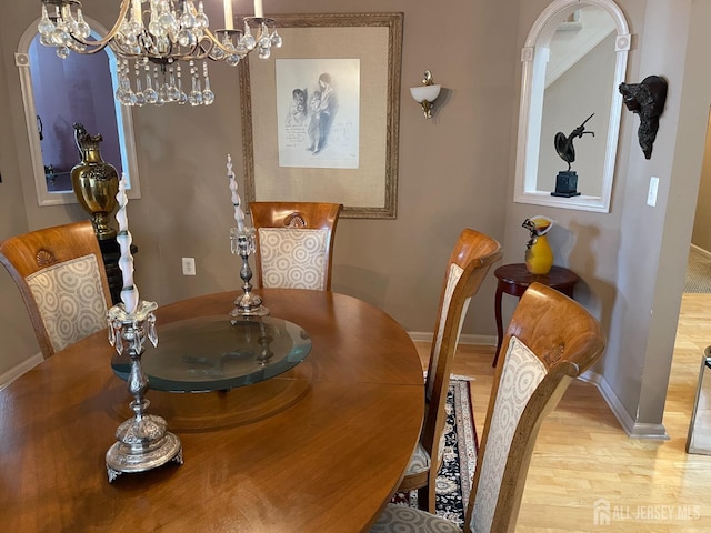 dining space with wood-type flooring and a chandelier