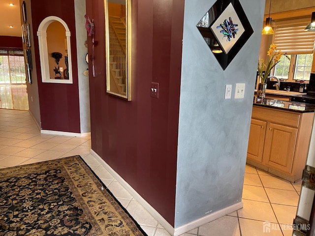 hall featuring sink and light tile patterned floors