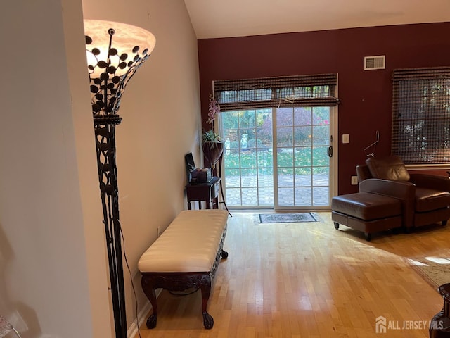 doorway with lofted ceiling and light hardwood / wood-style floors