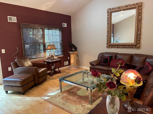 living room with light hardwood / wood-style floors and vaulted ceiling