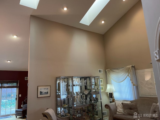 living room featuring a skylight and a high ceiling