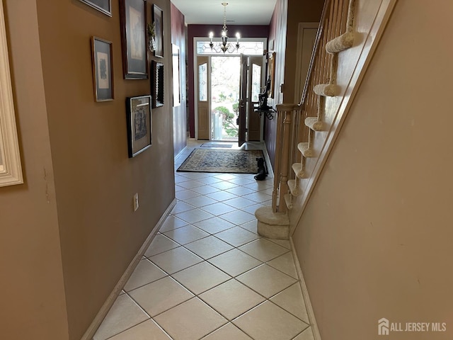 doorway to outside featuring light tile patterned flooring and an inviting chandelier