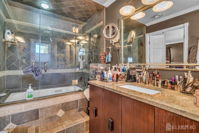 bathroom featuring crown molding, enclosed tub / shower combo, and vanity