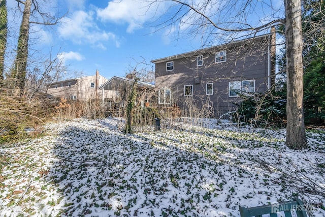 view of snow covered back of property