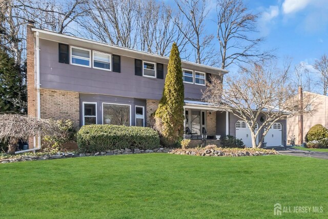 view of front of property featuring a garage, a porch, and a front yard