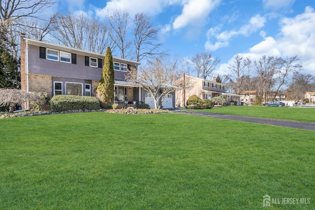 view of front of home with a garage and a front lawn