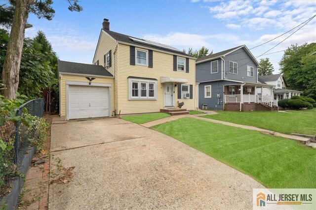 colonial house with a front lawn and a garage