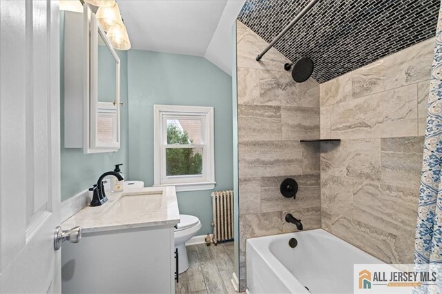 full bathroom featuring radiator, shower / tub combo with curtain, hardwood / wood-style flooring, vanity, and toilet