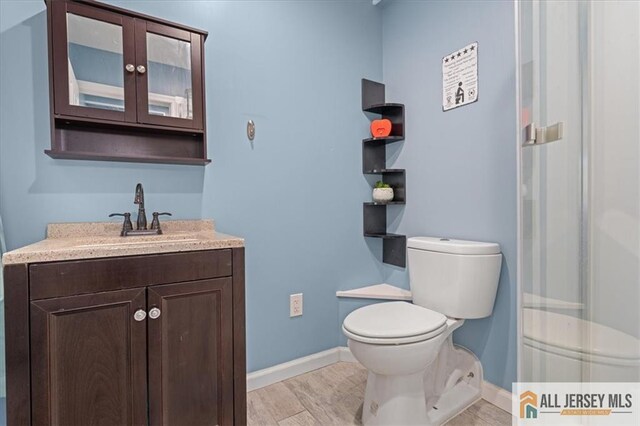 bathroom with hardwood / wood-style flooring, vanity, and toilet