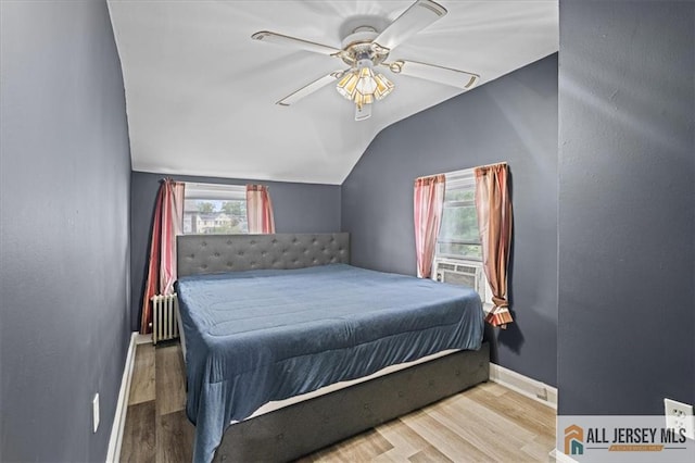 bedroom featuring lofted ceiling, radiator heating unit, wood-type flooring, and ceiling fan