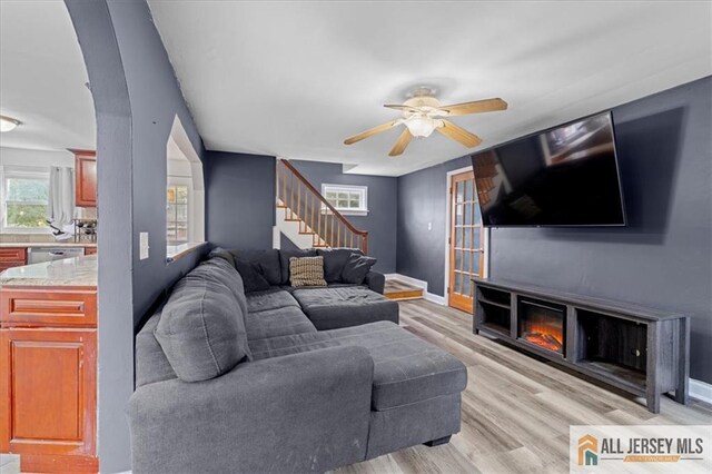 living room featuring ceiling fan and light hardwood / wood-style flooring