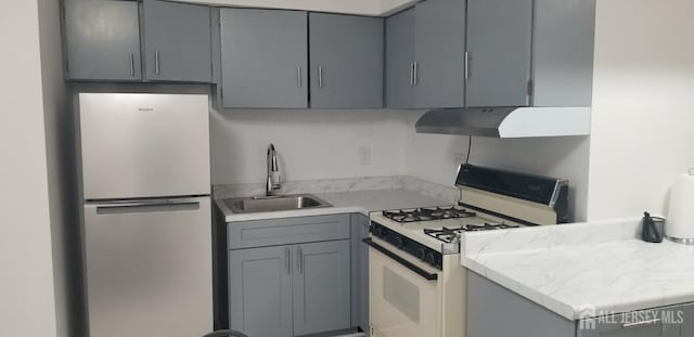 57 Judson St Unit 6A, Edison, NJ 08837 - kitchen featuring freestanding refrigerator, white gas range oven, gray cabinetry, and under cabinet range hood