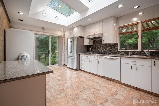 14 Bosko Dr, East Brunswick, NJ 08816 - kitchen with white dishwasher, a skylight, freestanding refrigerator, under cabinet range hood, and dark stone counters
