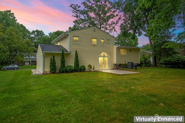 14 Bosko Dr, East Brunswick, NJ 08816 - back of house at dusk with a yard, a patio area, and french doors