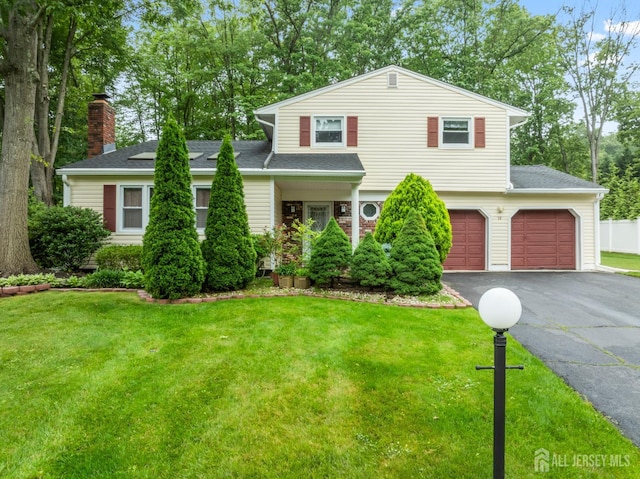 14 Bosko Dr, East Brunswick, NJ 08816 - view of front facade featuring asphalt driveway, a front lawn, a chimney, roof with shingles, and an attached garage