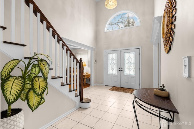 tiled entrance foyer with a high ceiling and french doors