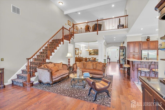 1 Ballybunion Dr, Monroe, NJ 08831 - living room with stairs, hardwood / wood-style floors, a towering ceiling, arched walkways, and a chandelier