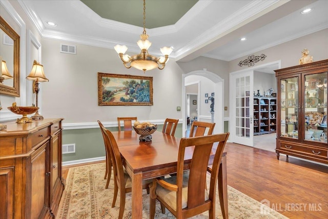 1 Ballybunion Dr, Monroe, NJ 08831 - dining area featuring arched walkways, light wood-style flooring, crown molding, a chandelier, and a raised ceiling