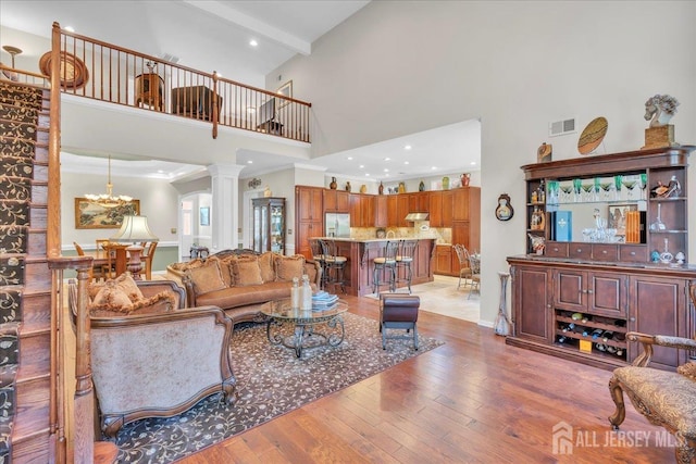 1 Ballybunion Dr, Monroe, NJ 08831 - living room with a high ceiling, decorative columns, light wood finished floors, and recessed lighting