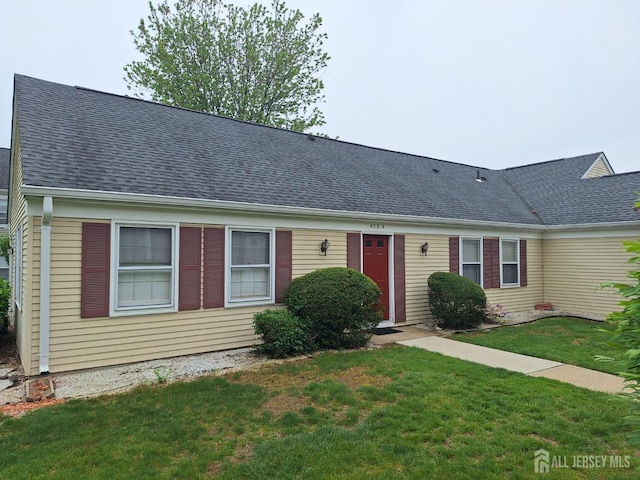 ranch-style house with roof with shingles and a front yard