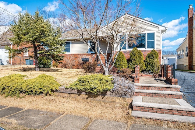 view of front of house with brick siding and fence