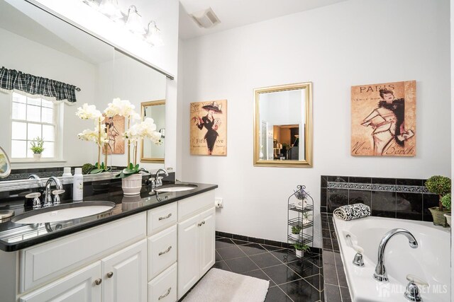 bathroom with vanity, tile patterned floors, and a relaxing tiled tub