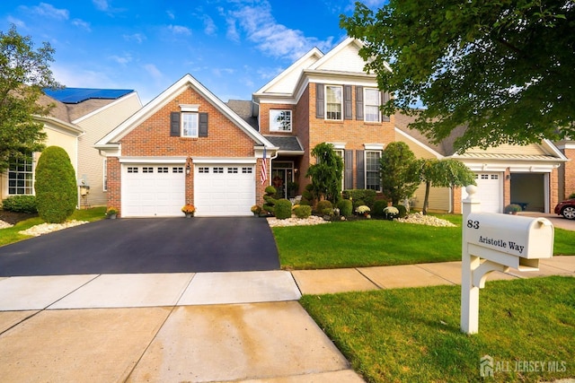 view of front of house featuring aphalt driveway, brick siding, a garage, and a front lawn