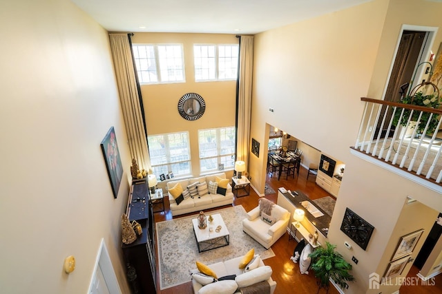 living room with a high ceiling and wood-type flooring