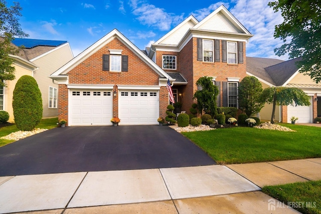 view of front of house with a garage and a front lawn