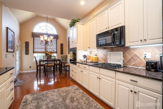 kitchen with black appliances, tasteful backsplash, hanging light fixtures, vaulted ceiling, and plenty of natural light