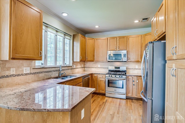 37 Muirfield Blvd, Monroe, NJ 08831 - kitchen with appliances with stainless steel finishes, a peninsula, ornamental molding, light stone countertops, and light wood finished floors
