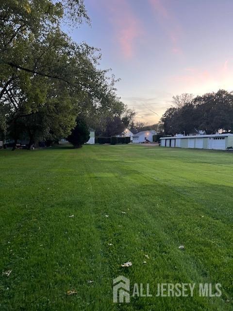 79 Davidson Mill Rd, South Brunswick, NJ 08902 - yard at dusk featuring a lawn