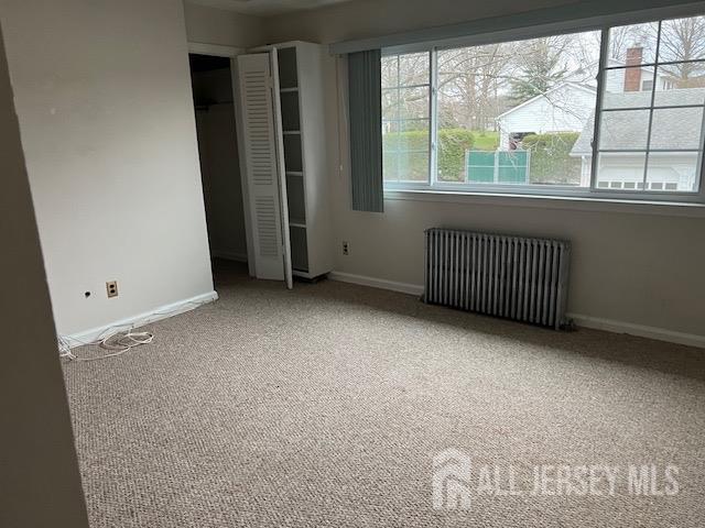 79 Davidson Mill Rd, South Brunswick, NJ 08902 - unfurnished bedroom with radiator, carpet flooring, baseboards, and a closet