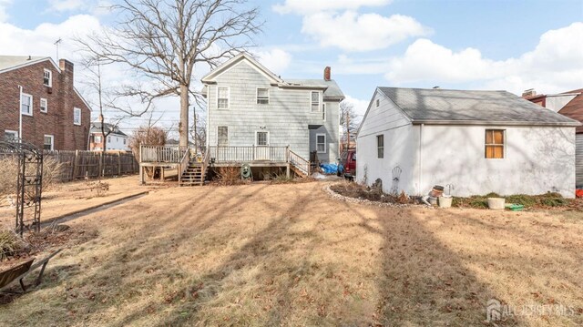 back of house with a deck and a yard