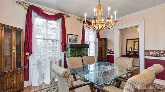 dining area featuring hardwood / wood-style floors, ornamental molding, and a chandelier