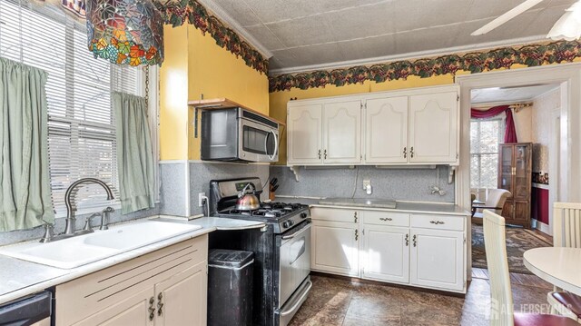 kitchen featuring decorative backsplash, sink, white cabinetry, and stainless steel appliances