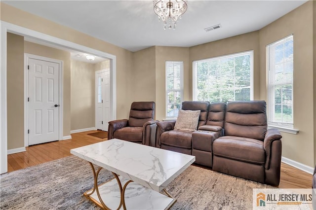 living room featuring wood finished floors, baseboards, and a chandelier