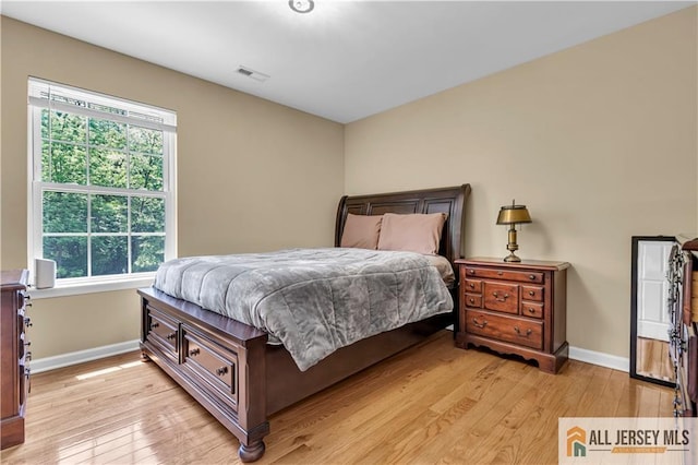 bedroom featuring light wood finished floors and baseboards