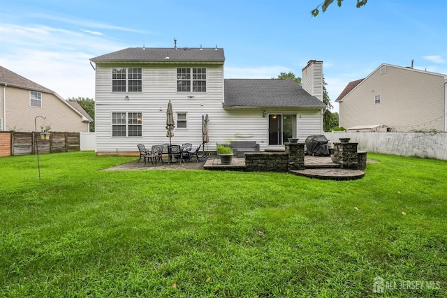 rear view of house with a yard and a patio area